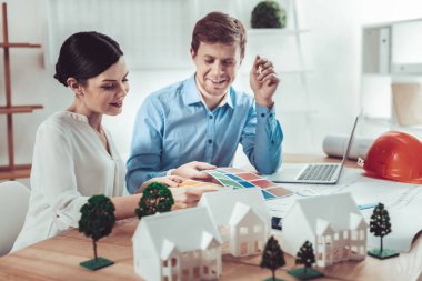 Bu daha iyi olur. Neşeli arkadaşları modern yerleşim için renk seçerken işyerinde oturan