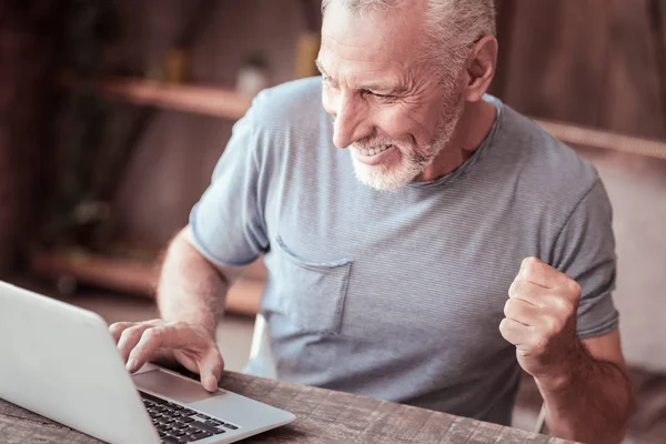 Крупним планом задоволений літній чоловік використовує ноутбук — стокове фото