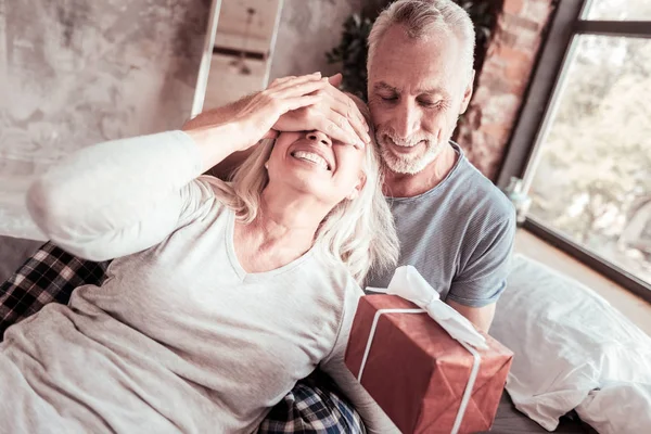 Elderly man presenting surprise for his wife — Stock Photo, Image