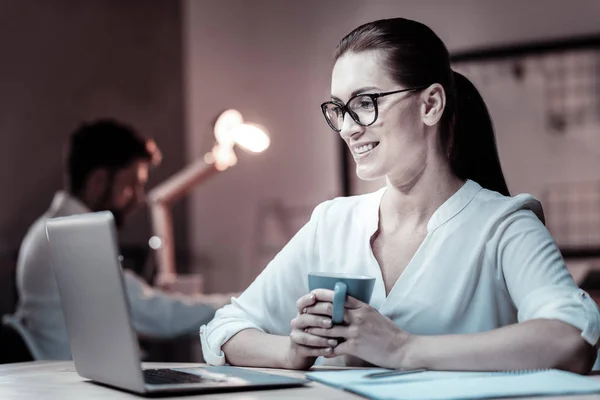 Charmiga kvinnlig person som innehar cup i båda händerna — Stockfoto