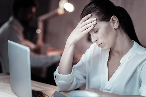 Mujer agotada tocándose la frente — Foto de Stock