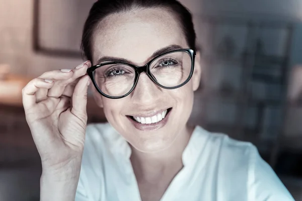 Happy bruneta dotýká její brýle — Stock fotografie