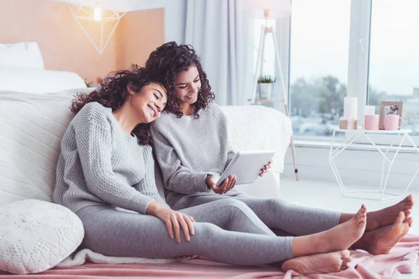 Curly-haired systrarna känsla utvilad titta på film — Stockfoto