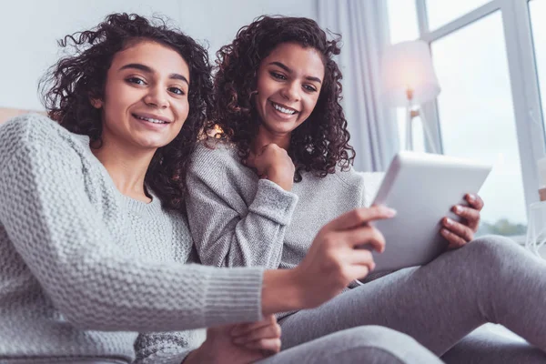 Hermanas encantadoras se sienten ocupadas mientras charlan a través de Internet — Foto de Stock