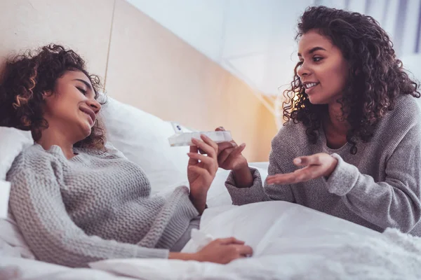 Careful friend visiting her sick friend suffering from flu at home — Stock Photo, Image