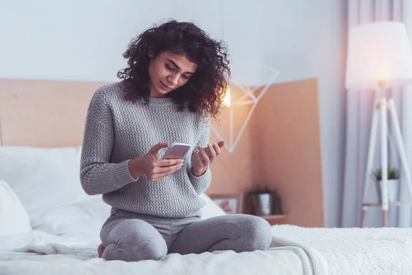 Joven freelancer revisando su correo electrónico en un teléfono inteligente — Foto de Stock