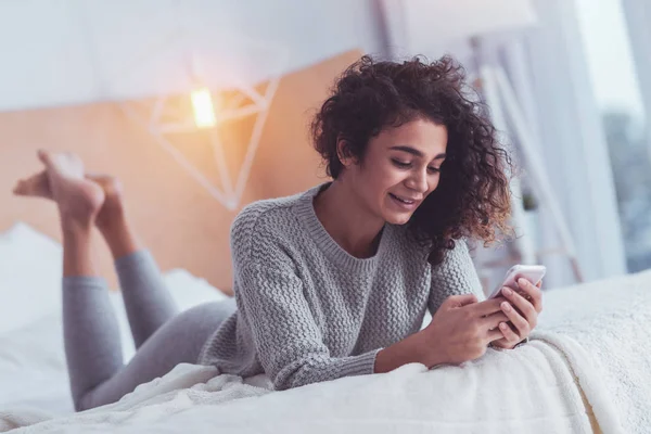 Mujer joven relajada sintiéndose aliviada acostada en la cama — Foto de Stock