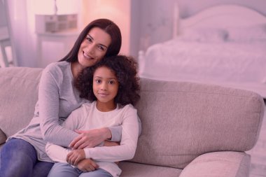 Neşeli mutlu anne ve kızı kanepede oturan