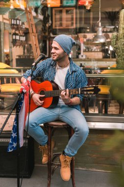 Mutlu erkek gitarist şarkıyı çalmaya çevre bar