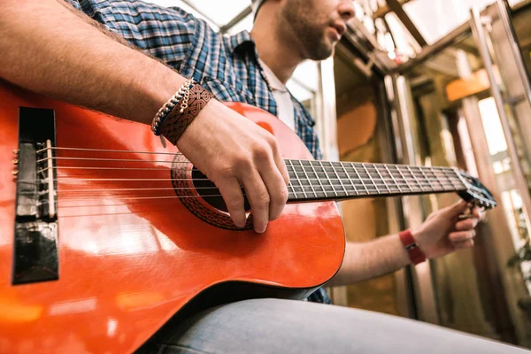 Skäggiga manliga gitarrist lyssnar på ljud på gitarr — Stockfoto