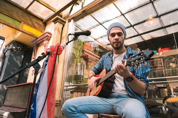 Guitarrista masculino guapo disfrutando de la música en la guitarra —  Fotos de Stock