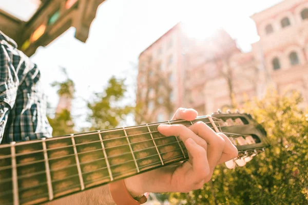 Mains tendres masculines appuyant sur la corde contre les frets — Photo