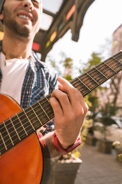 Vigoroso guitarrista masculino experimentando con acordes en la calle — Foto de Stock