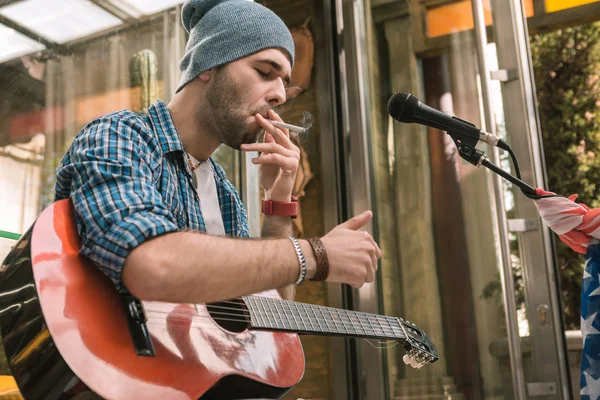 Focado guitarrista masculino acendendo cigarro na rua — Fotografia de Stock