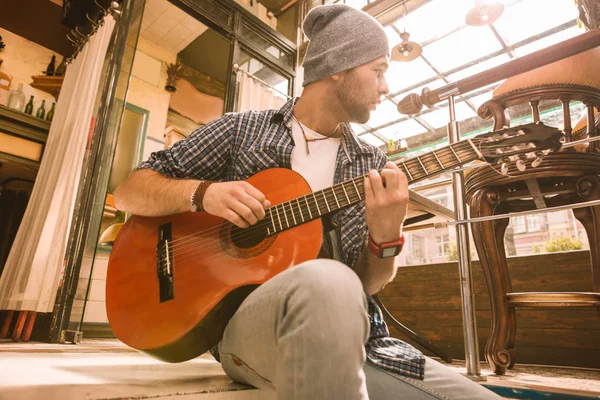 Distraído guitarrista masculino em jejum escolher na guitarra — Fotografia de Stock