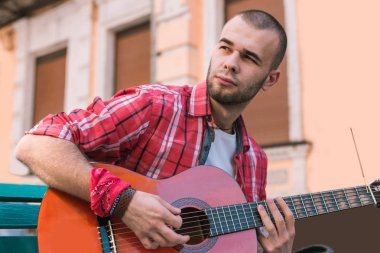 Büyüleyici Sokak müzisyeni gitar pratikte çeker