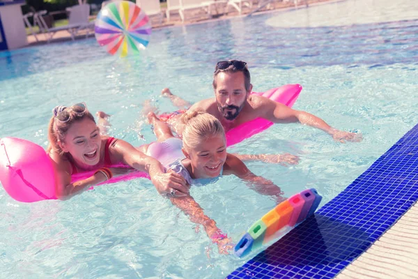 Agradable mujer alegre sosteniendo a sus hijas hombro — Foto de Stock