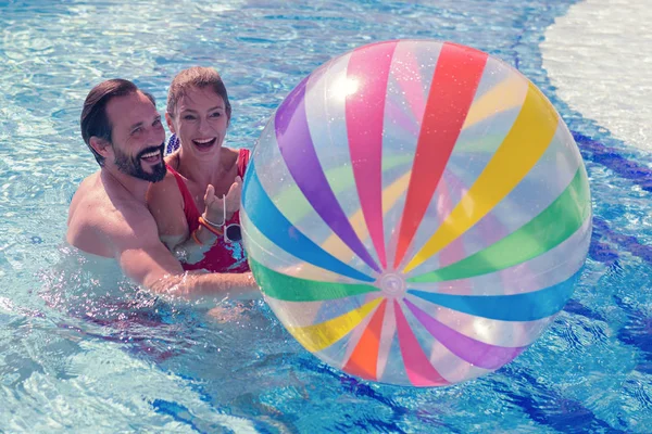 Alegre pareja positiva jugando con una pelota —  Fotos de Stock