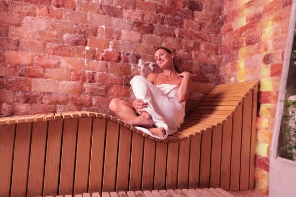 Aantrekkelijke positieve vrouw zittend op het houten bankje — Stockfoto
