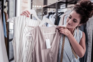 Moda Tasarımcısı beyaz ve koyu bej yazlık elbise arasında seçme