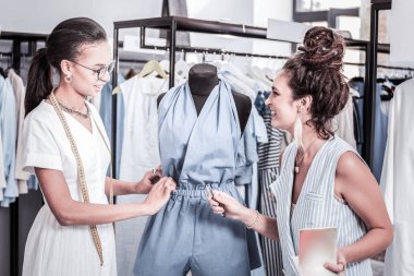 Onun siyah saçlı stajyer bazı emirleri neşeli kıvırcık moda tasarımcısı