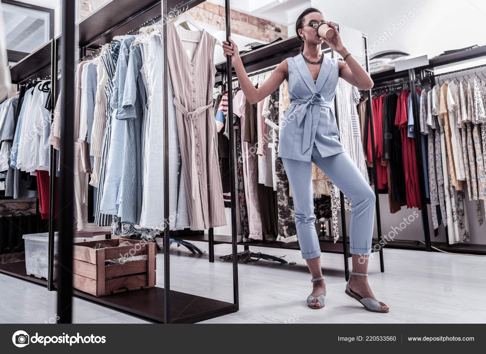Woman Shopping In Boutique Drinking Coffee Before Going To