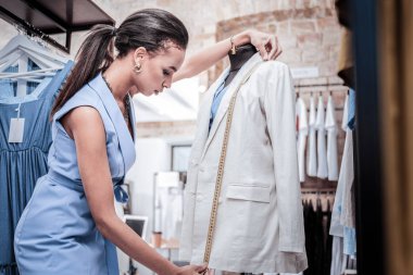 At kuyruğu ayakta uzun bej ceketi ile vücut formu yakınındaki tasarımcısıyla