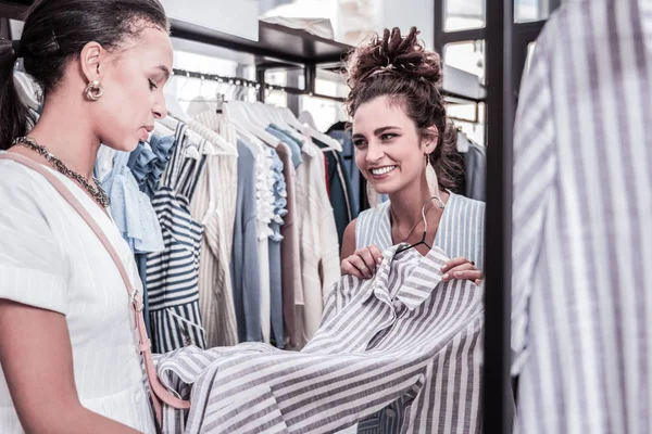 Agradable asistente de compras recomendando bonito vestido de su visitante constante — Foto de Stock