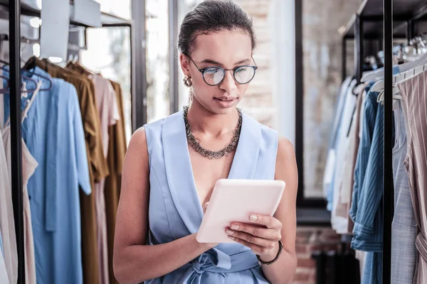 Drukke dark-haired zakenvrouw holding haar tablet lezen van zakelijke e-mail — Stockfoto