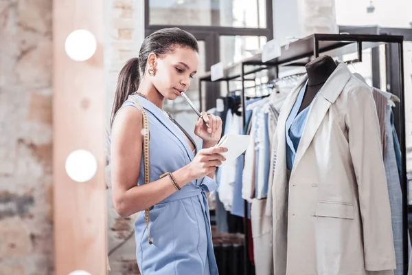 Designer wearing stylish elegant vest feeling unsure about choosing fabrics