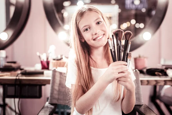 Красивая девушка держит кисти для макияжа — стоковое фото