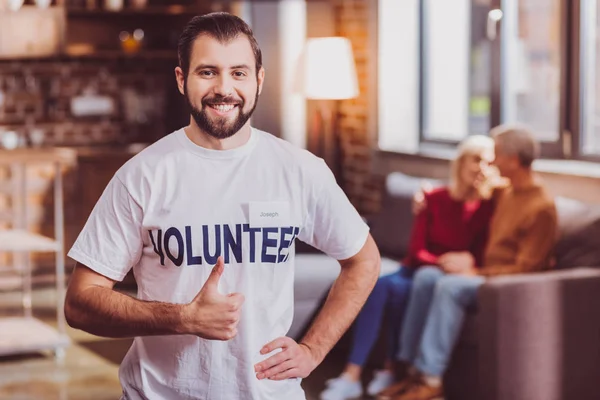 Voluntário alegre mostrando seu polegar para cima — Fotografia de Stock