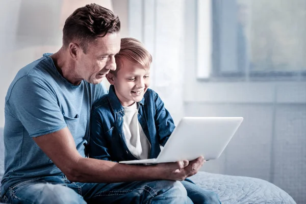 Ικανοποιημένοι μικρό αγόρι χρησιμοποιώντας το φορητό υπολογιστή και χαμογελαστός. — Φωτογραφία Αρχείου