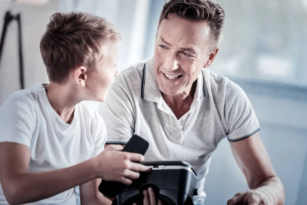 Agradável homem satisfeito sorrindo e olhando para seu filho . — Fotografia de Stock