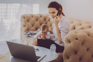 Serbest çalışan anne çocuğunu uykuda lulling süre telefonda konuşan