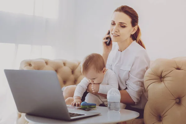 Concerned young mother calling pediatrician while nursing little child — Stock Photo, Image