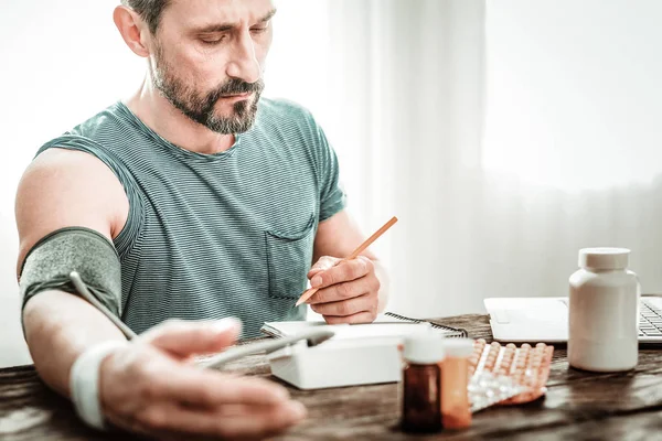 Cheerless chateado adulto homem segurando um lápis — Fotografia de Stock