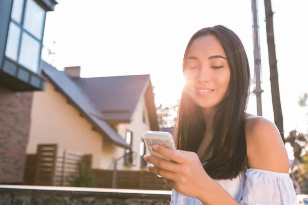 Positive delighted woman looking at her smartphone — Stock Photo, Image