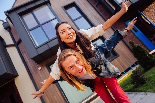 Positieve getrouwd paar staande voorkant van het huis — Stockfoto