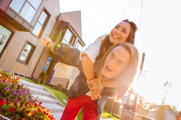 Heureux couple positif debout devant leur maison — Photo