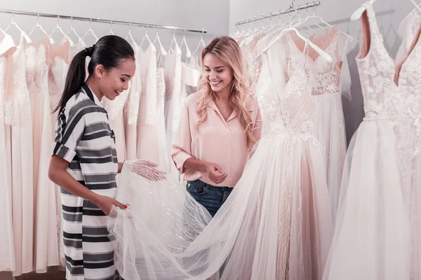 Nice young woman holding a wedding dress — Stock Photo, Image