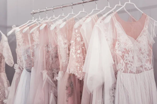 Belos vestidos de noiva pendurados em cabides na loja — Fotografia de Stock