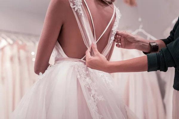 Piacevole bella donna che tocca un abito da sposa — Foto Stock