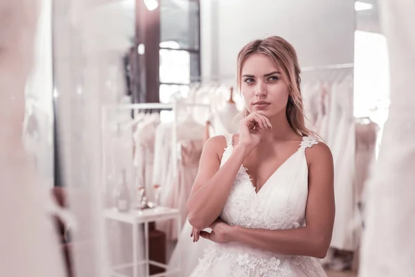 Bonita mulher pensativa de pé na boutique de casamento — Fotografia de Stock