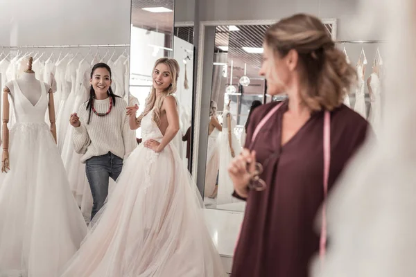 Radosny młodych kobiet patrząc na ślub sukienka projektanta — Zdjęcie stockowe