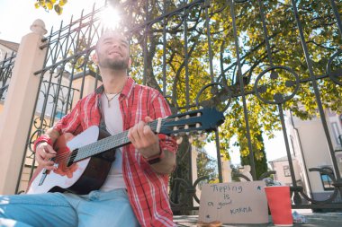 Oyun için para isteyen memnun Sokak müzisyeni