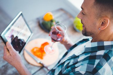 Tablet ekrana bakarak neşeli pozitif adam