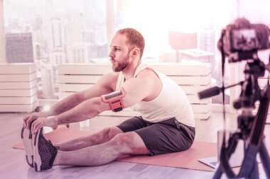 Profil konsantre sporcunun yerdeki gerilme egzersizleri yapıyor