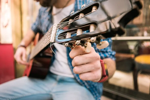 Bepaald mannelijke gitarist tuning gitaar voor het afspelen van — Stockfoto