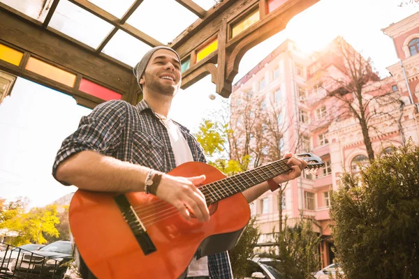 Inspirado guitarrista masculino fazendo as pessoas felizes com a música — Fotografia de Stock